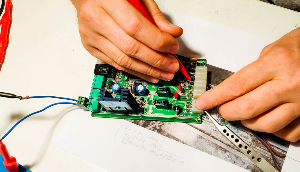 Une carte électronique d'abri de piscine est en train d'être contrôlée par un ingénieur électronicien