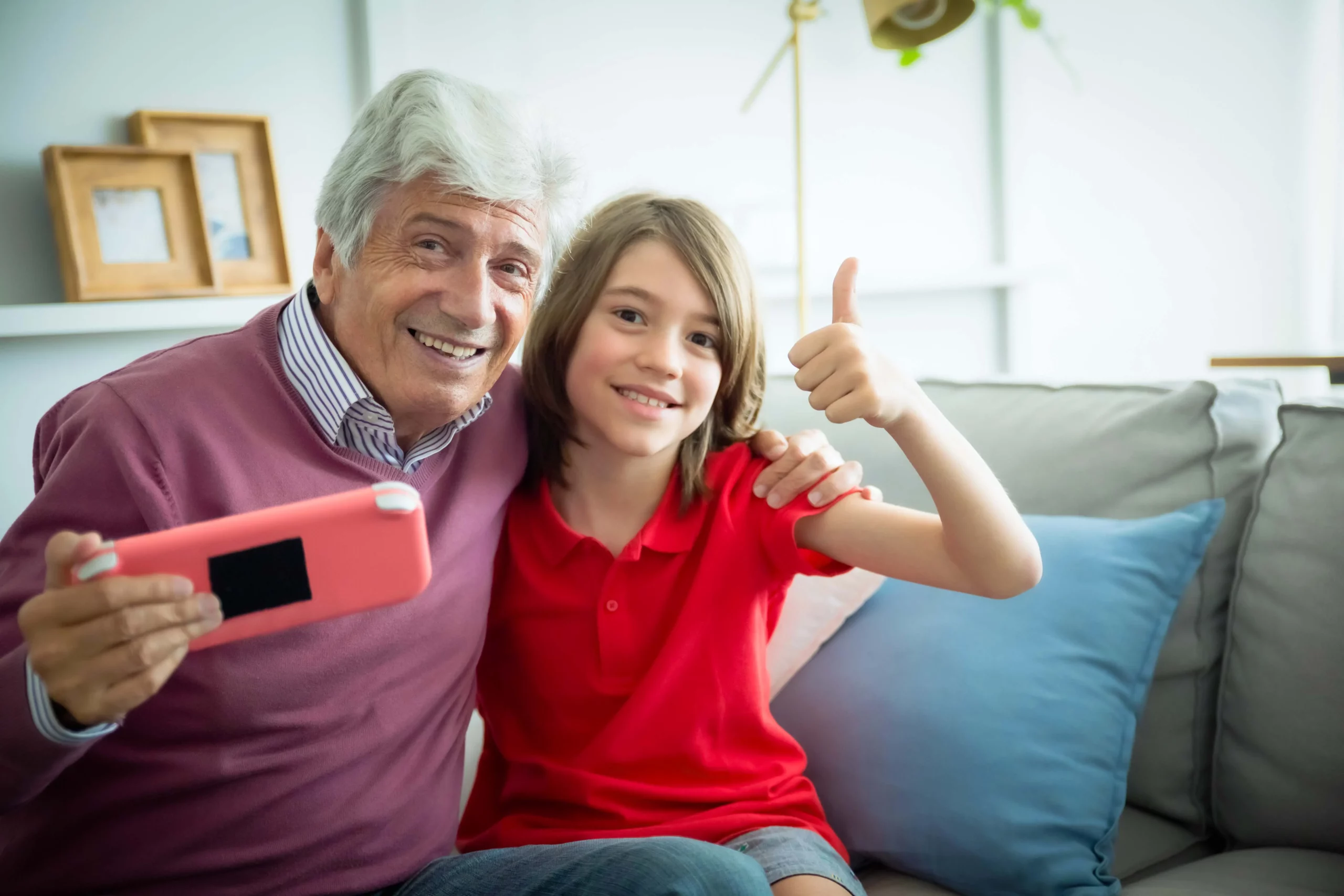 Un papy avec son petit fils qui tient un appareil électrique dans la main